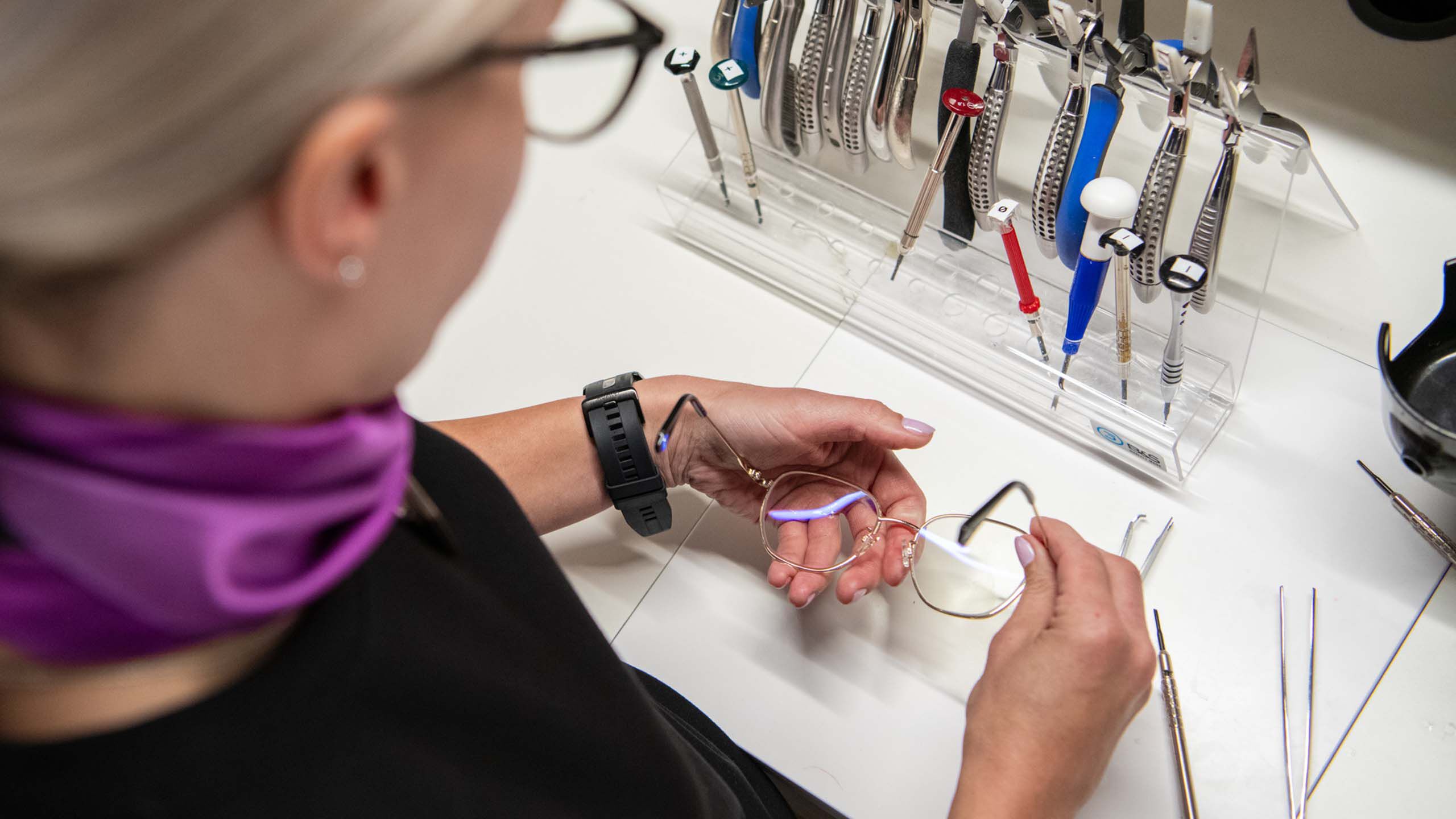 Optikko korjaa silm&auml;lasikehyst&auml;.